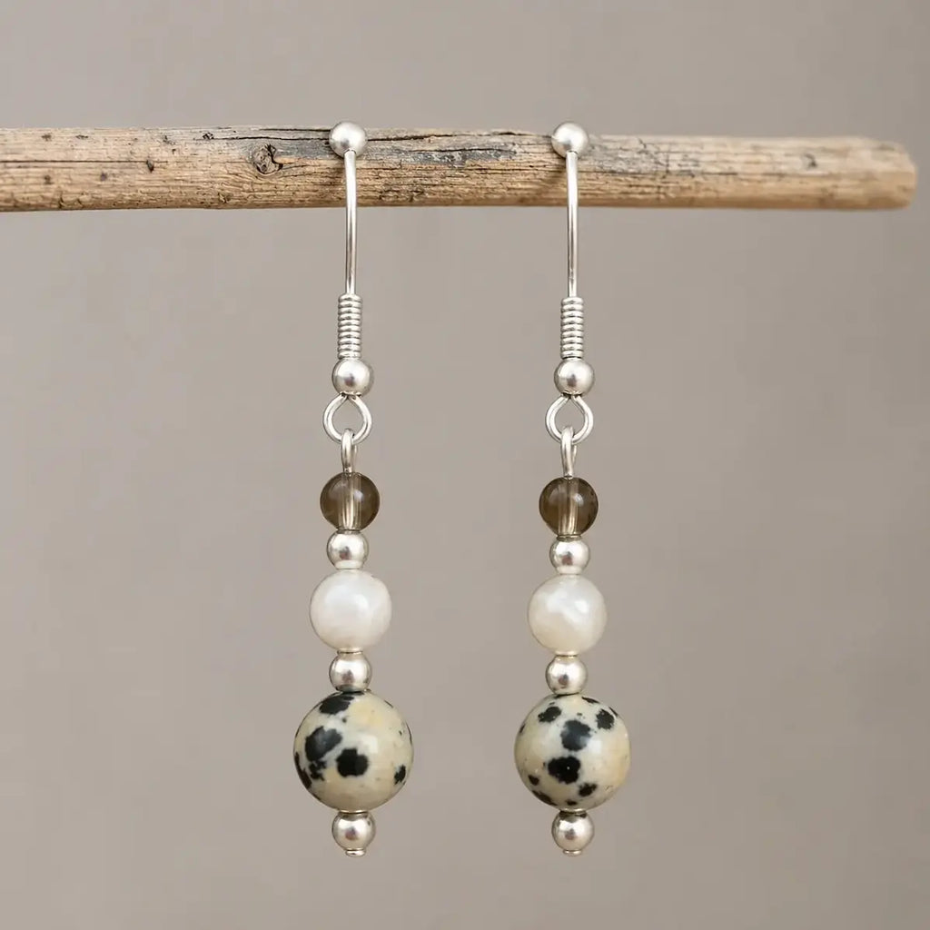 Calm and Clear Earrings with smoky quartz, moonstone, and dalmatian jasper gemstones on silver hook.