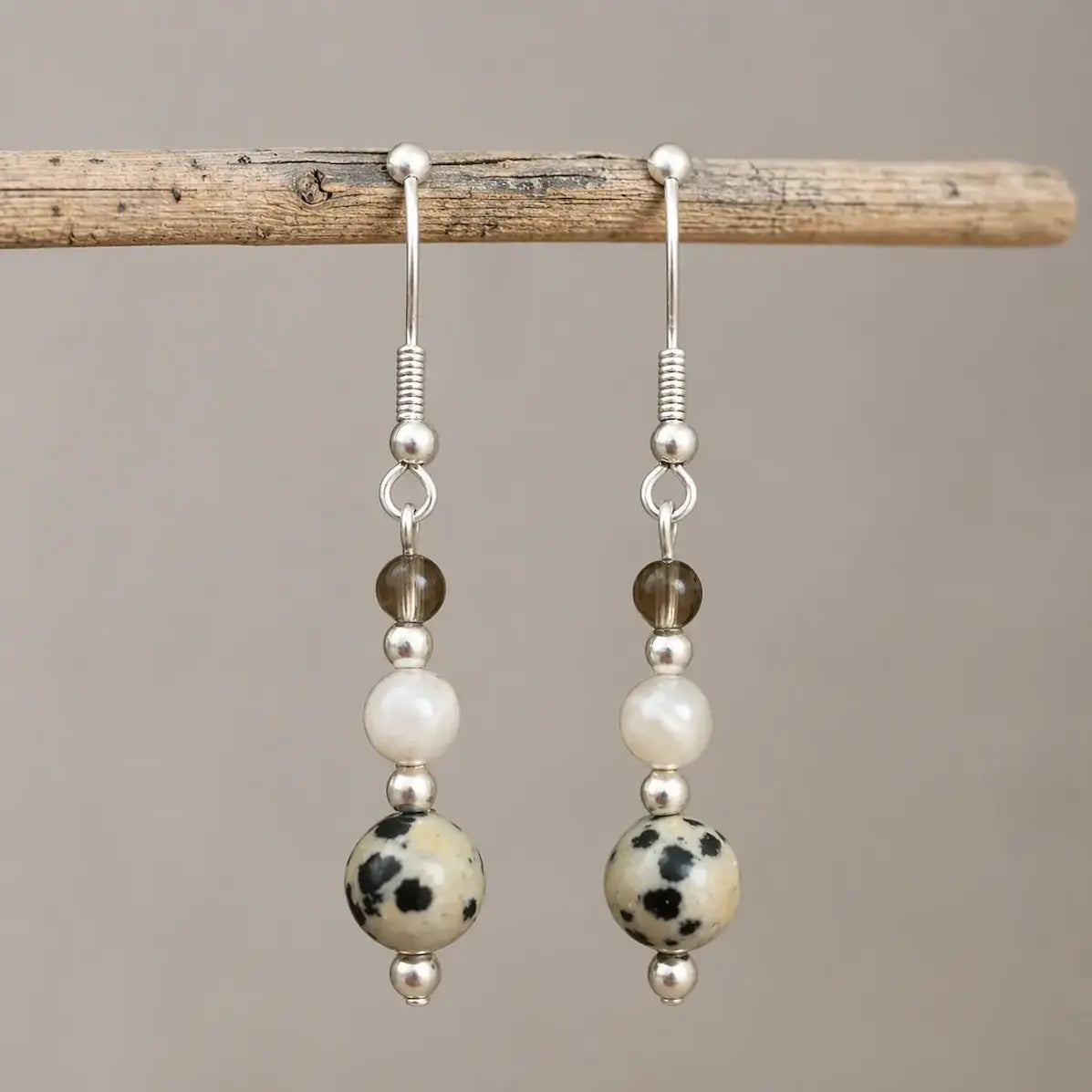 Calm and Clear Earrings with smoky quartz, moonstone, and dalmatian jasper gemstones on silver hook.