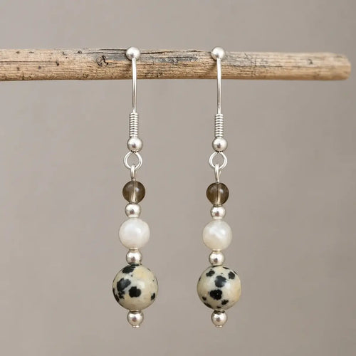 Calm and Clear Earrings with smoky quartz, moonstone, and dalmatian jasper gemstones on silver hook.