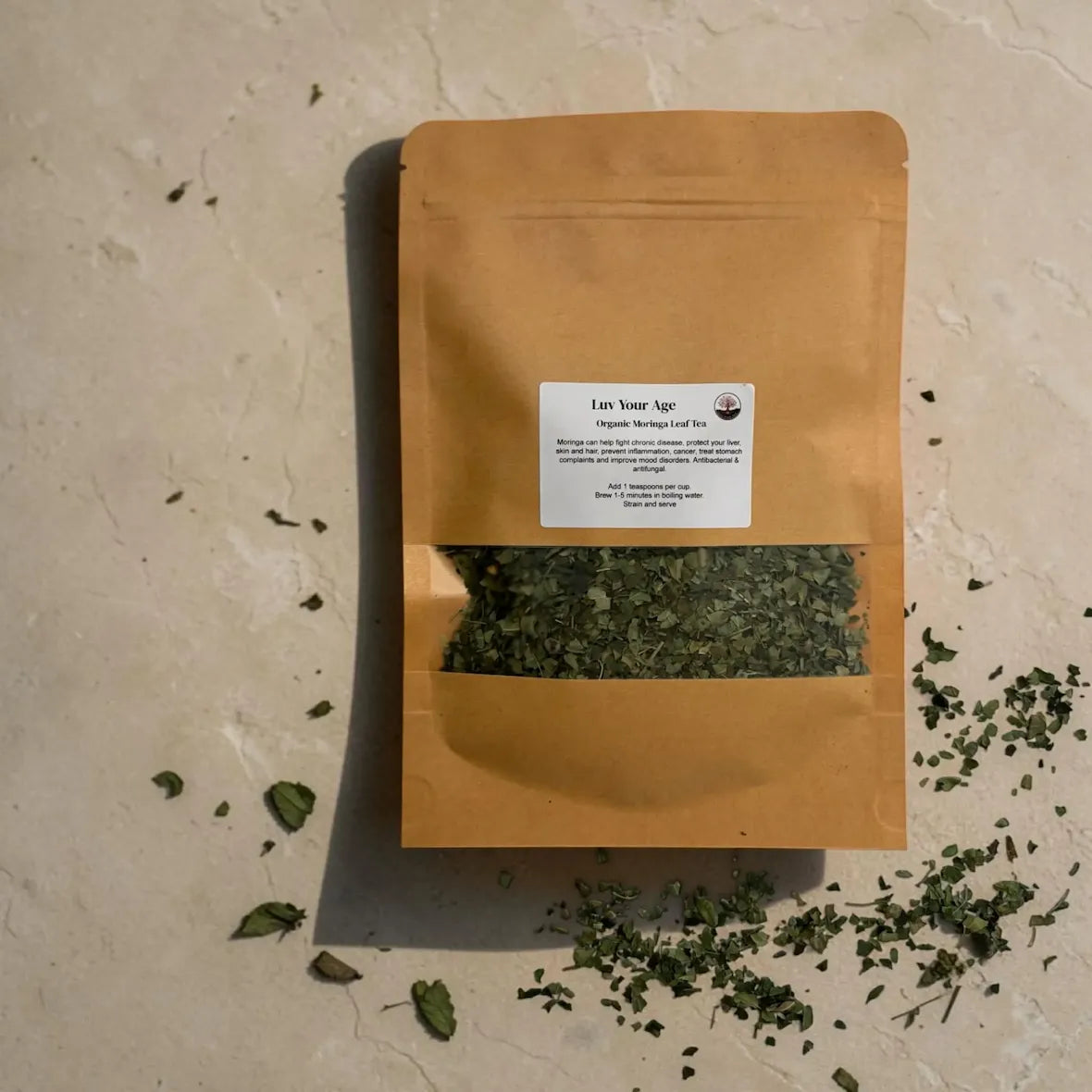 Brown paper package with fine cuts moringa on a beige surface.